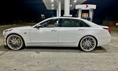 a white car parked in front of a gas station