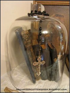 a glass dome with books and a cross on the top is sitting on a table