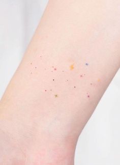 a person's arm with small stars on the left side of their body and one foot