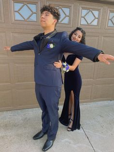 a man in a suit and tie standing next to a woman wearing a black dress