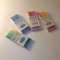 four different colored pens sitting next to each other on top of a white countertop