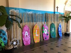 surfboards are lined up against a wall with the word aloh painted on them