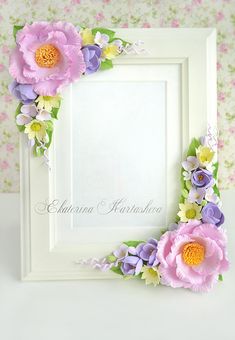 a white frame decorated with paper flowers