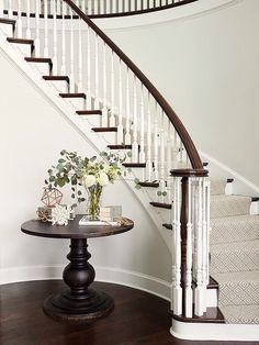 there is a vase with flowers on the table in front of the bannister