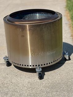 a large metal pot sitting on top of a sidewalk