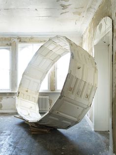 a large white object sitting in the middle of a room next to a radiator