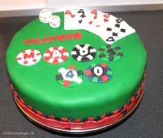 a green cake decorated with playing cards and dice