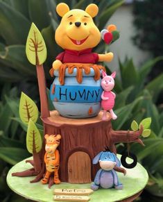 a winnie the pooh figurine sitting on top of a tree stump with other toys