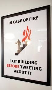 a sign on the wall that says in case of fire exit building before tweeting about it