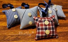 three decorative pillows with buttons on them sitting on a wooden table next to each other