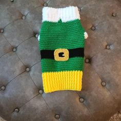 a green and yellow knitted hat sitting on top of a couch