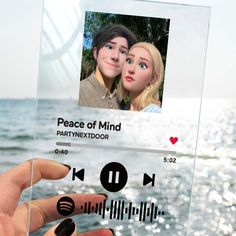 someone is holding up a glass plaque with the words peace of mind and an image of two people