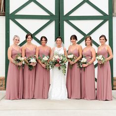 a group of women standing next to each other in front of a green barn door