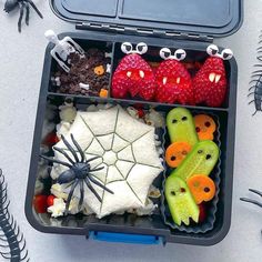 a bento box filled with halloween food and fake spider webs on the side