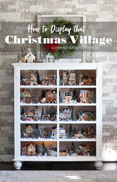 a white china cabinet with christmas decorations on top and the words how to display that christmas village