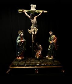 a crucifix with three people and a cross in the middle on a black background