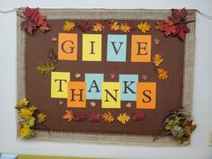 a bulletin board with the words give thanks written on it and fall leaves around it