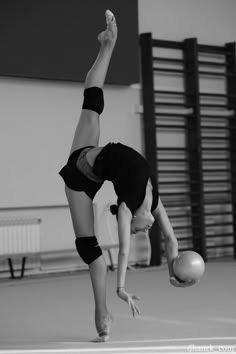 a man doing a handstand while holding a soccer ball