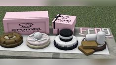 an assortment of cakes on display in front of a pink box with the word crumbl cookies