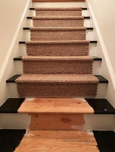 a set of stairs with carpet on the bottom and handrails in between them