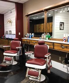 a barber shop with red chairs and mirrors