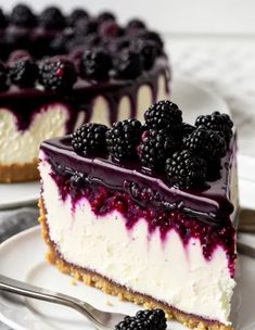 a slice of cheesecake with blueberries and blackberries on top is sitting on a plate