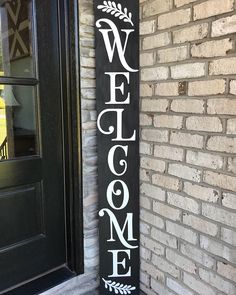 a welcome sign hanging on the side of a brick building