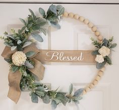 a wreath that has flowers and leaves around it with the word, blessed on it