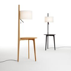 two lamps are next to each other and one is on the floor with a table