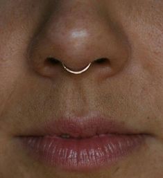 a woman's nose with a thin nose ring on it