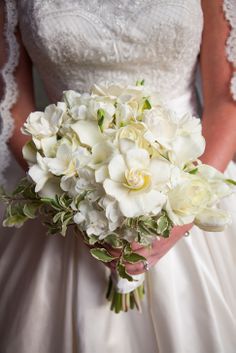 a bride holding a bouquet of white flowers