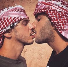 two men with heads coverings kissing each other