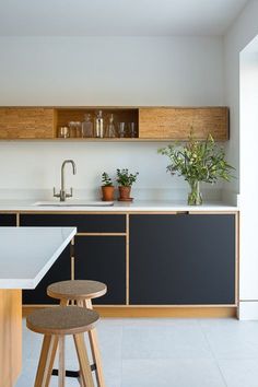 a kitchen with black cabinets and white counter tops