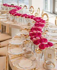 the table is set with pink roses and gold place settings for an elegant wedding reception