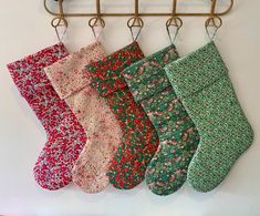 five stockings hanging from a rack on a wall