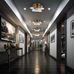 a long hallway with pictures on the wall and lights hanging from it's ceiling