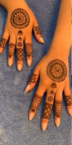 two hands with henna tattoos on them