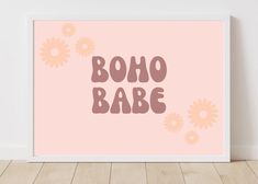 a pink poster with the words boho babe on it in front of a white wall