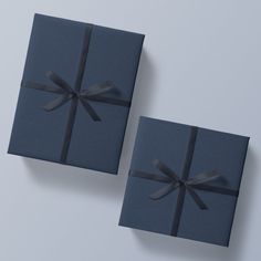 two blue gift boxes with black ribbons on them