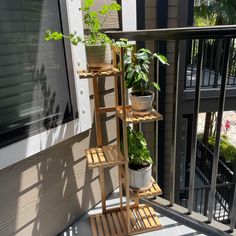 a plant stand on the porch with potted plants