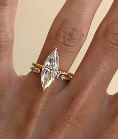 a woman's hand with a ring on it and a diamond in the middle