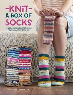 a woman sitting on top of a couch next to a pile of knitted socks