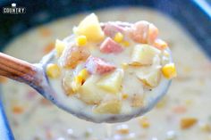 a spoon full of soup with ham and corn