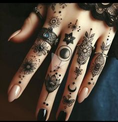 a woman's hand with tattoos and rings on her fingers, both decorated with flowers