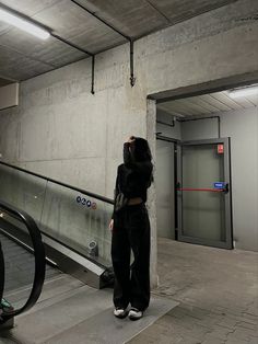 a woman standing on an escalator with her head in her hands