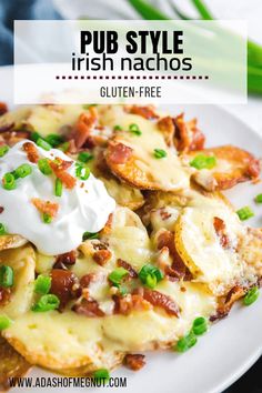 a white plate topped with potato shells covered in sour cream and bacon next to green onions