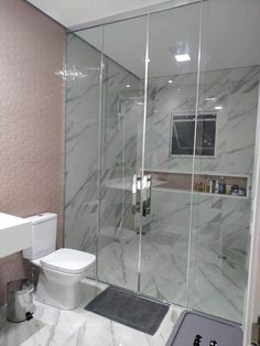 a white toilet sitting next to a walk in shower