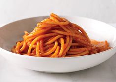 a white bowl filled with pasta on top of a table