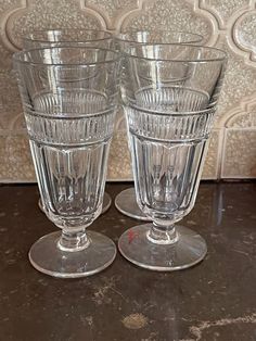 two clear glasses sitting on top of a table