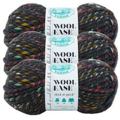 three skeins of wool ease yarn in multi - colored, black and grey colors